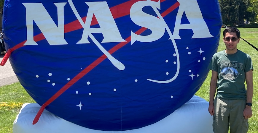 UC Merced student Tejas Bhartia is pictured next to a NASA sign